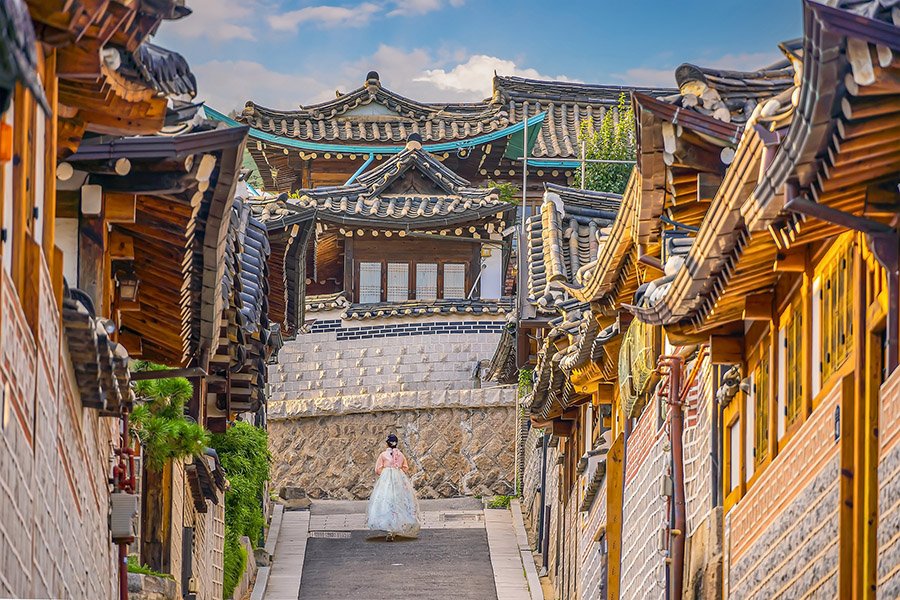 Girl wearing hanbok walking through Bukchon Hanok