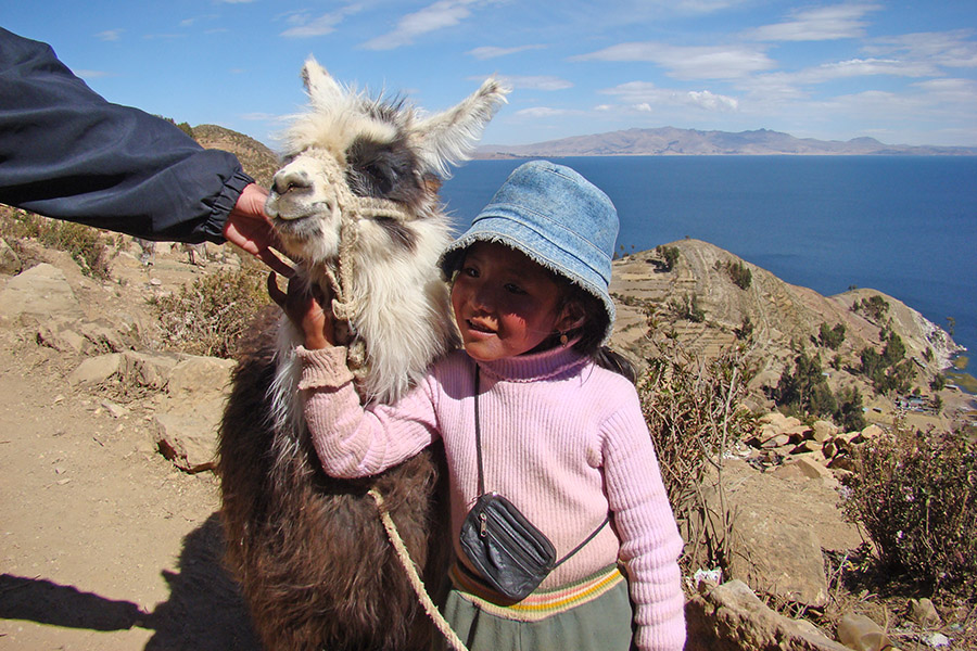 Little girl and llama on Isla del Sol