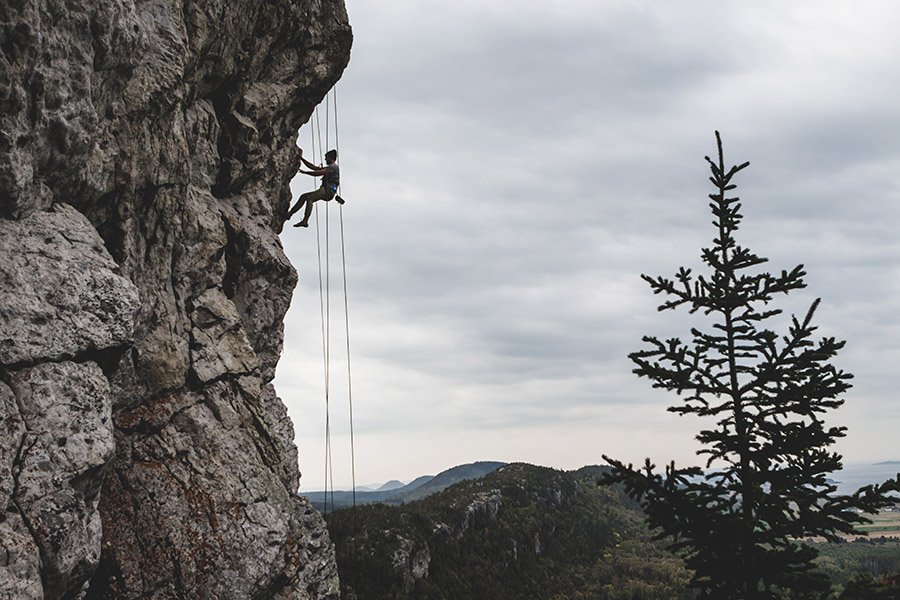 Person rock climbing with ropes