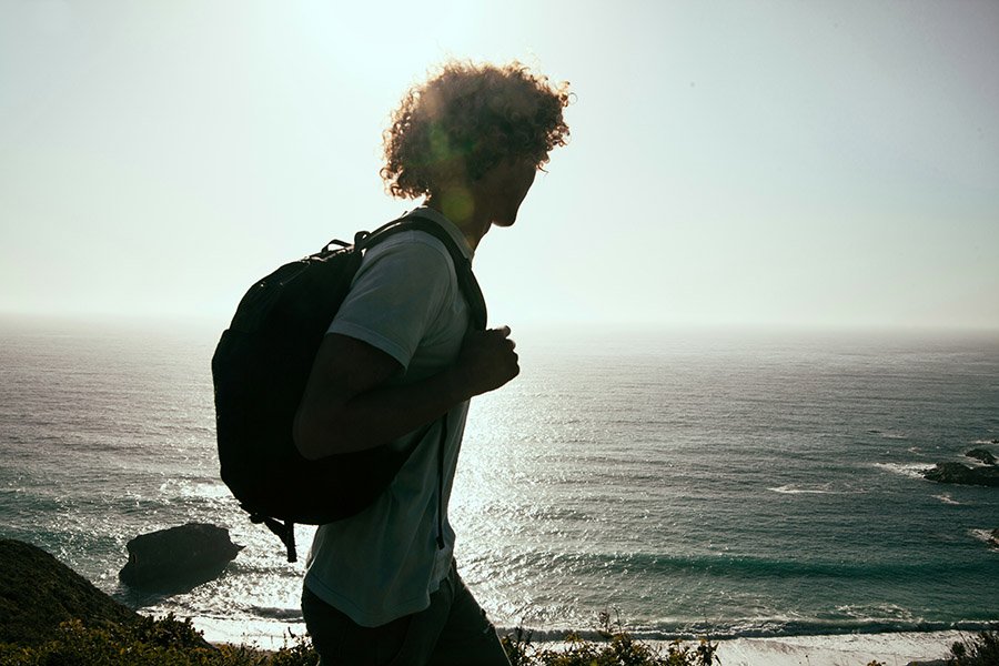 Student walking along the sea