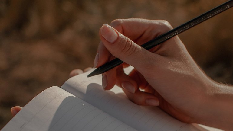 Person writing outdoors