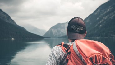 Student backpacker at a lake