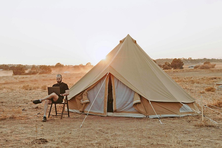 Blogger working on laptop near his tent