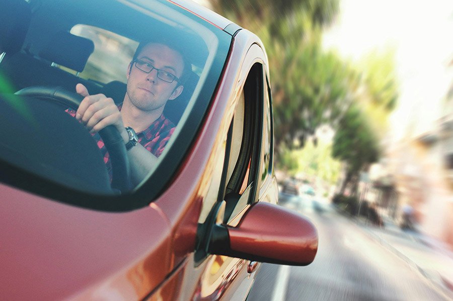 Man driving a red car