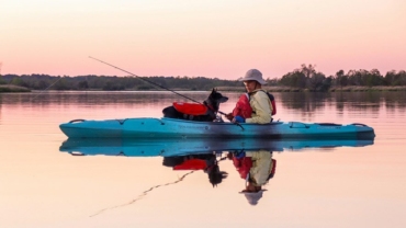 Man kayaking with a dog