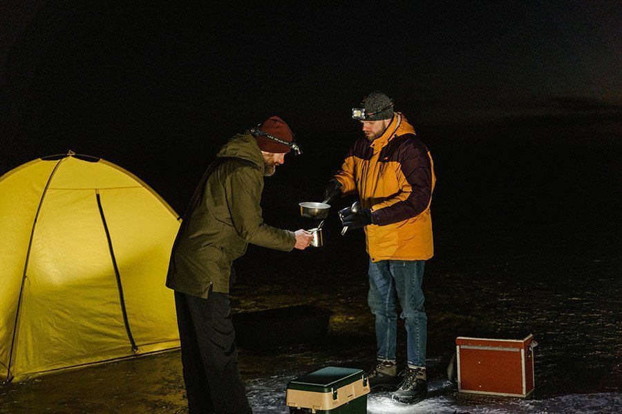 Campers preparing hot drinks in winter